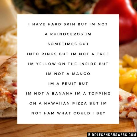 I have hard skin but Im not a rhinoceros
Im sometimes cut into rings but Im not a tree
Im yellow on the inside but Im not a mango
Im a fruit but Im not a banana
Im a topping on a Hawaiian pizza but Im not ham

What could I be?